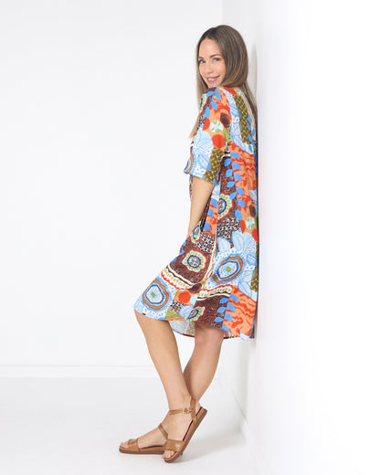 Eva Cotton Dress in ripple abstract print, side view leaning on a wall