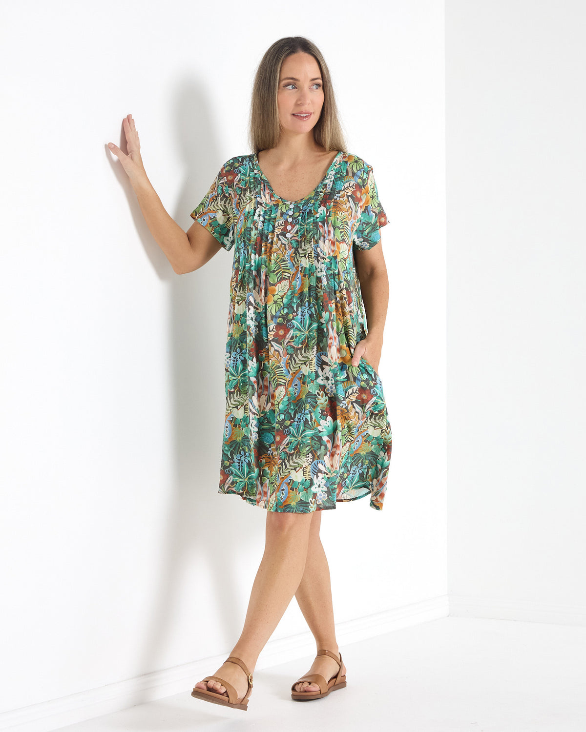 Hayes Cotton Dress in midnight jungle print, three-quarter view leaning on a wall, showing the pocket