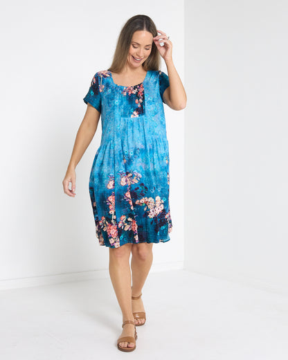 Emery Pintuck Dress in blue lagoon, front view in motion showing the swing skirt