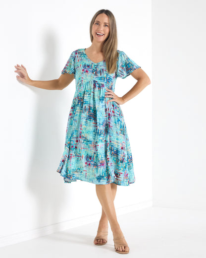 Cornwall Petite Dress in aqua mosaic print, front view with hand on hip, showing the midi length