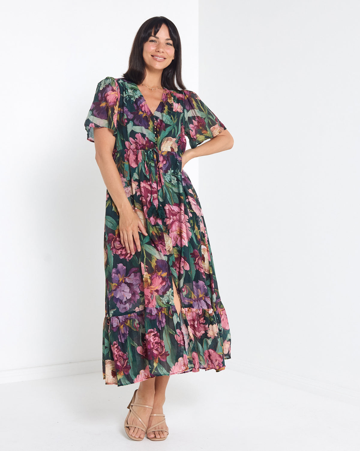 Cresida Party Dress in emerald floral, front view with hand on hip, showing the tie waist
