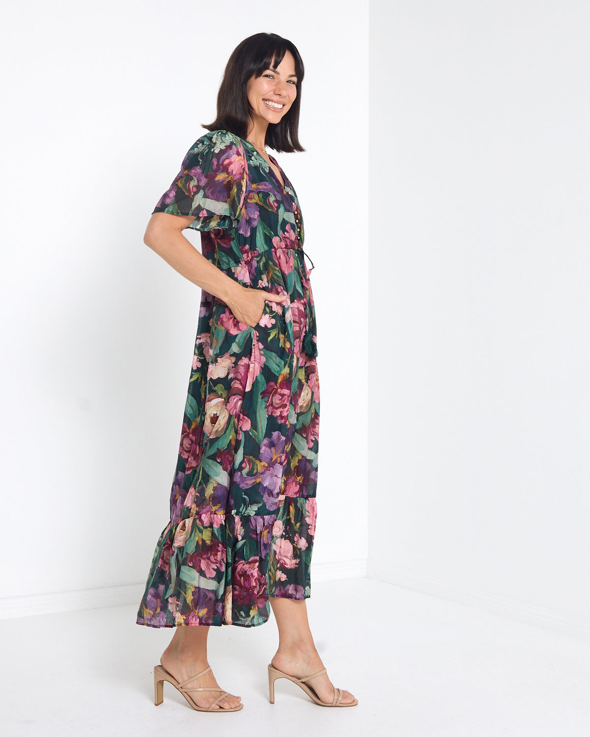 Cresida Party Dress in emerald floral, side view with hand in pocket
