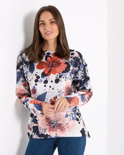 Woman wearing a colorful floral sweater against a white background
