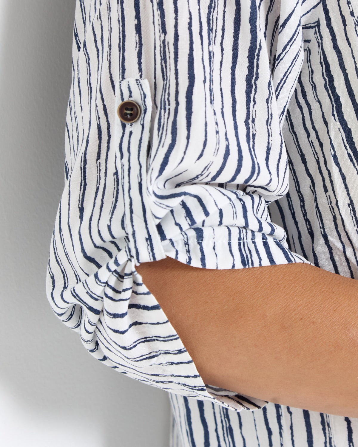 Gifford Stripe Blouse in navy, close-up of the button tab on the rolled sleeve