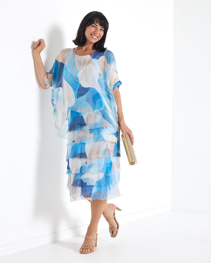 Margo Silk Layered Dress in Blue Celeste print, women's occasion midi dress with sheer overlay and fringed layered skirt, front view, arm raised