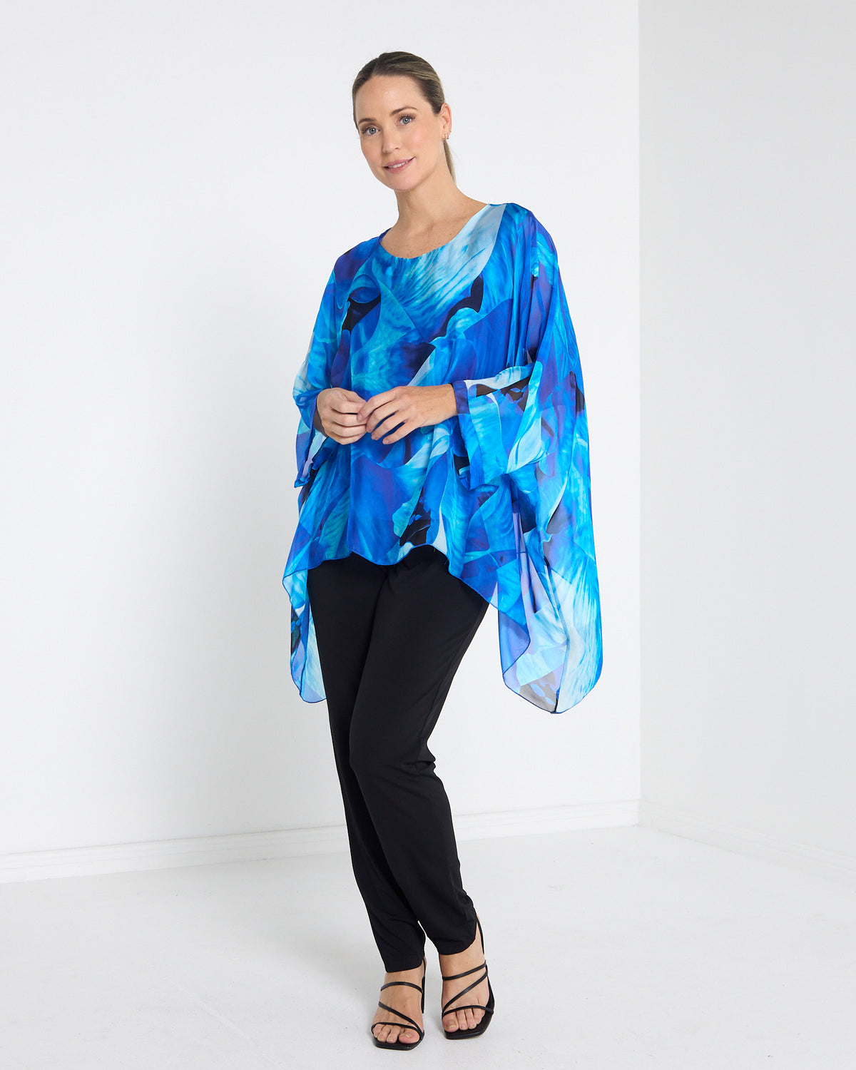 Palermo Silk Top in blue floral, full-length front view with black pants and heels