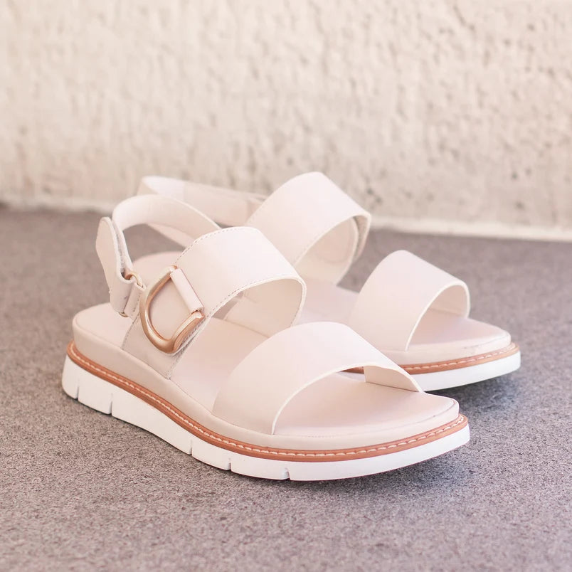 Sana Velcro Sandal in bone, pair on a stone step showing the gold D-ring and wide straps