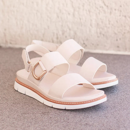 Sana Velcro Sandal in bone, pair on a stone step showing the gold D-ring and wide straps