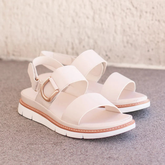 Sana Velcro Sandal in bone, pair on a stone step showing the gold D-ring and wide straps