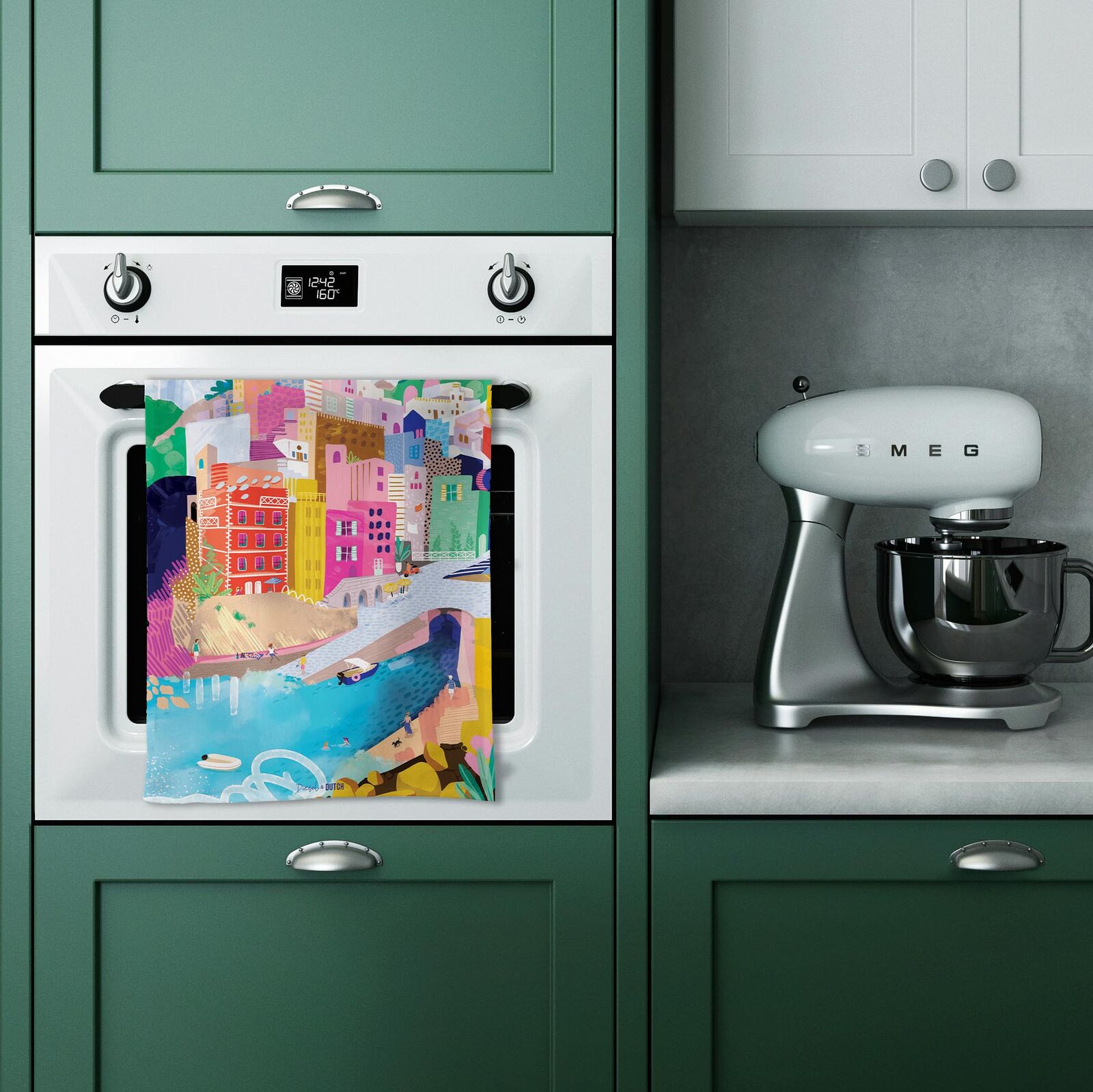 Kitchen with green cabinets, Smeg mixer, and colorful towel on oven door.