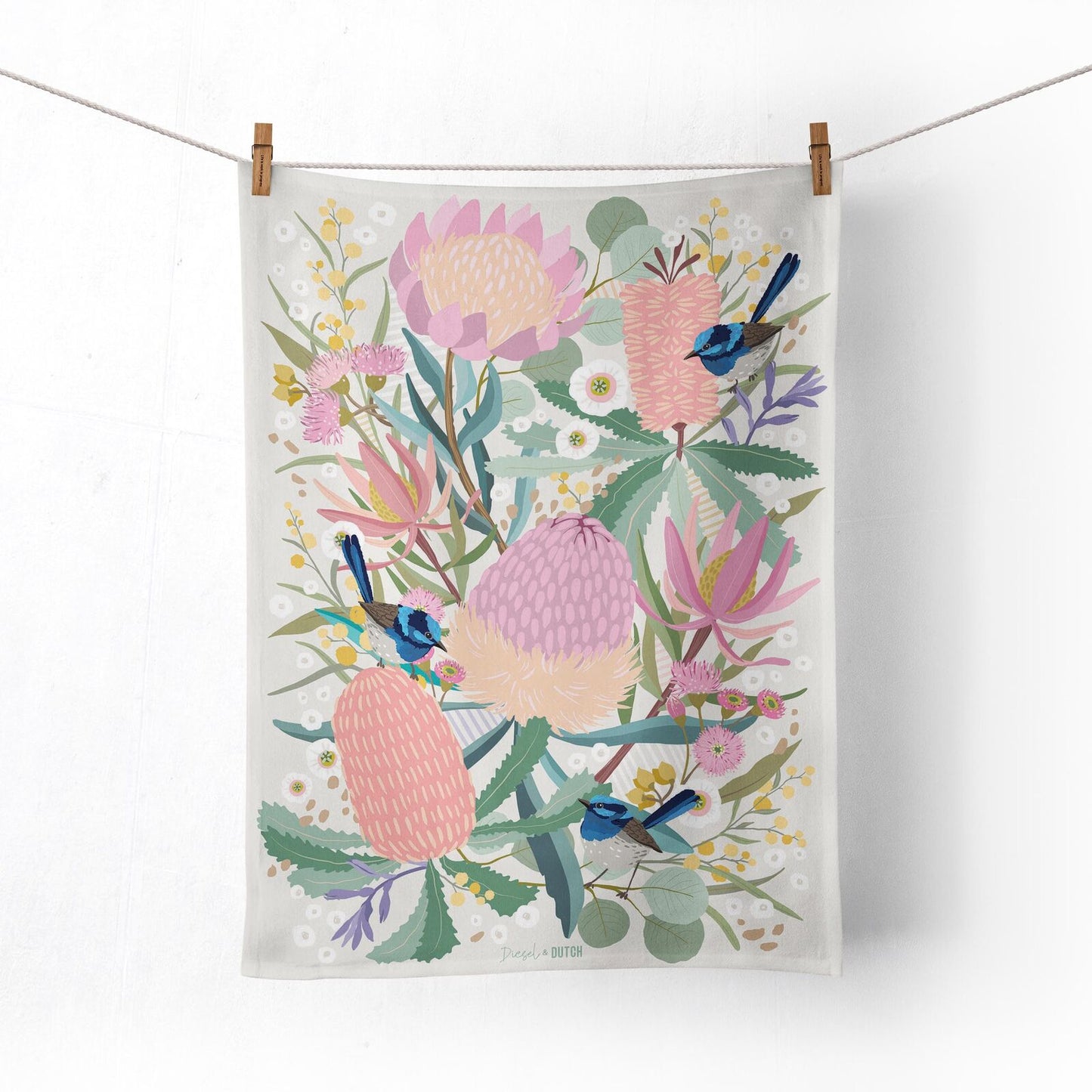 Tea towel with floral design and birds hanging on a line.