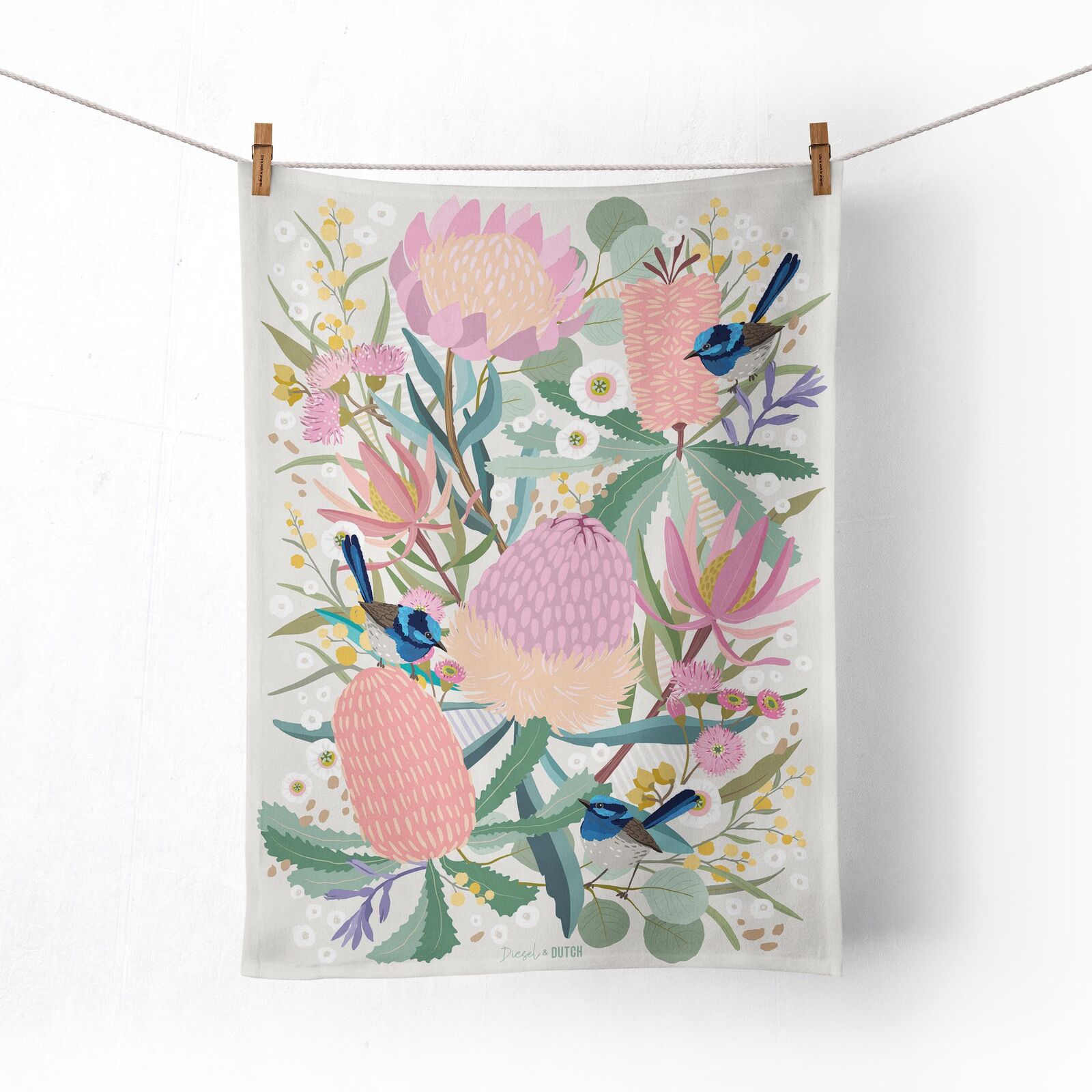 Tea towel with floral design and birds hanging on a line.