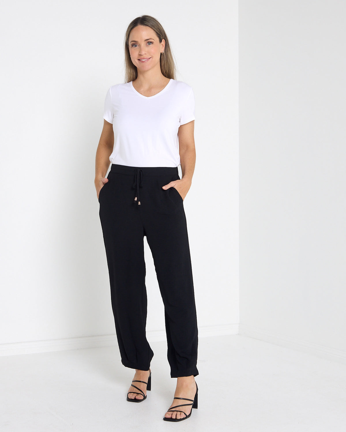 Venus Drawstring Tapered Pants in black, full-length view worn with a white tee and heels