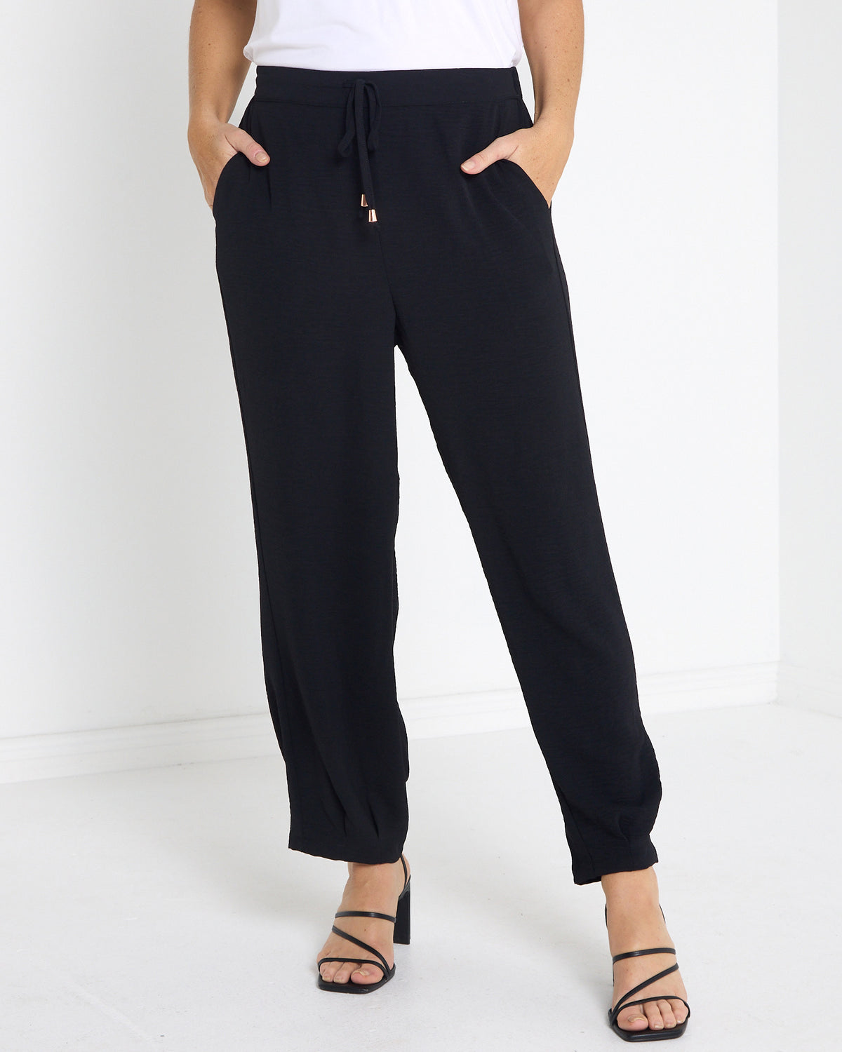 Venus Drawstring Tapered Pants in black, front view with drawstring waist and side pockets