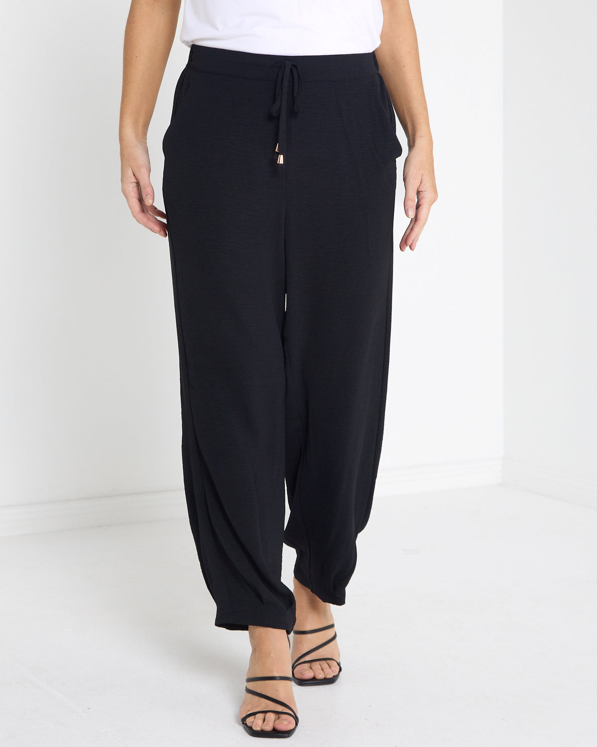 Venus Drawstring Tapered Pants in black, front view of the drawstring waist and tapered ankle