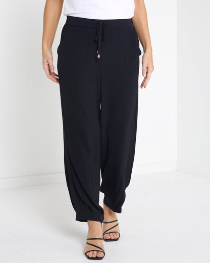 Venus Drawstring Tapered Pants in black, front view of the drawstring waist and tapered ankle
