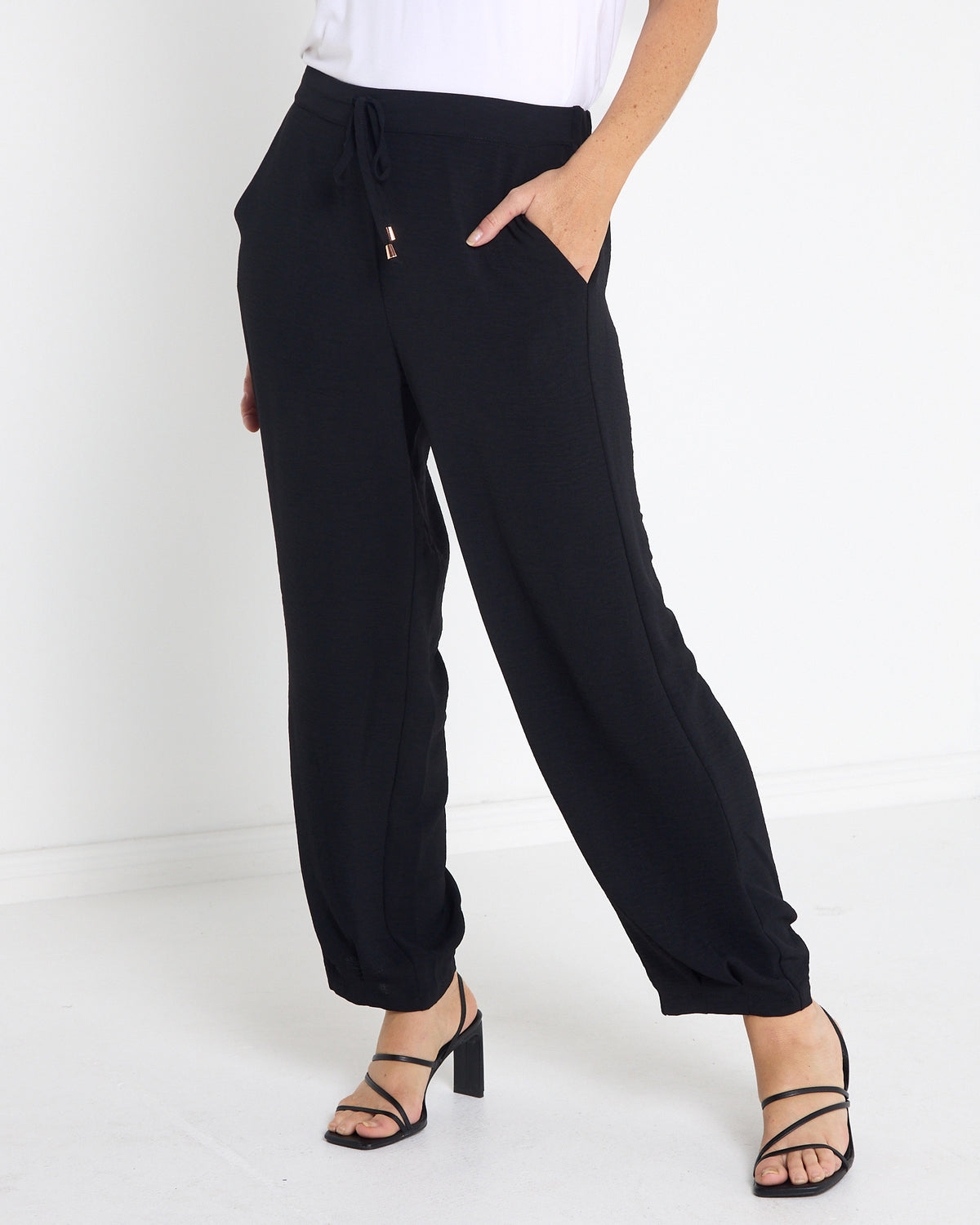 Venus Drawstring Tapered Pants in black, three-quarter view showing the relaxed leg and pocket