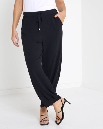 Venus Drawstring Tapered Pants in black, angled view showing the side pocket and tapered leg
