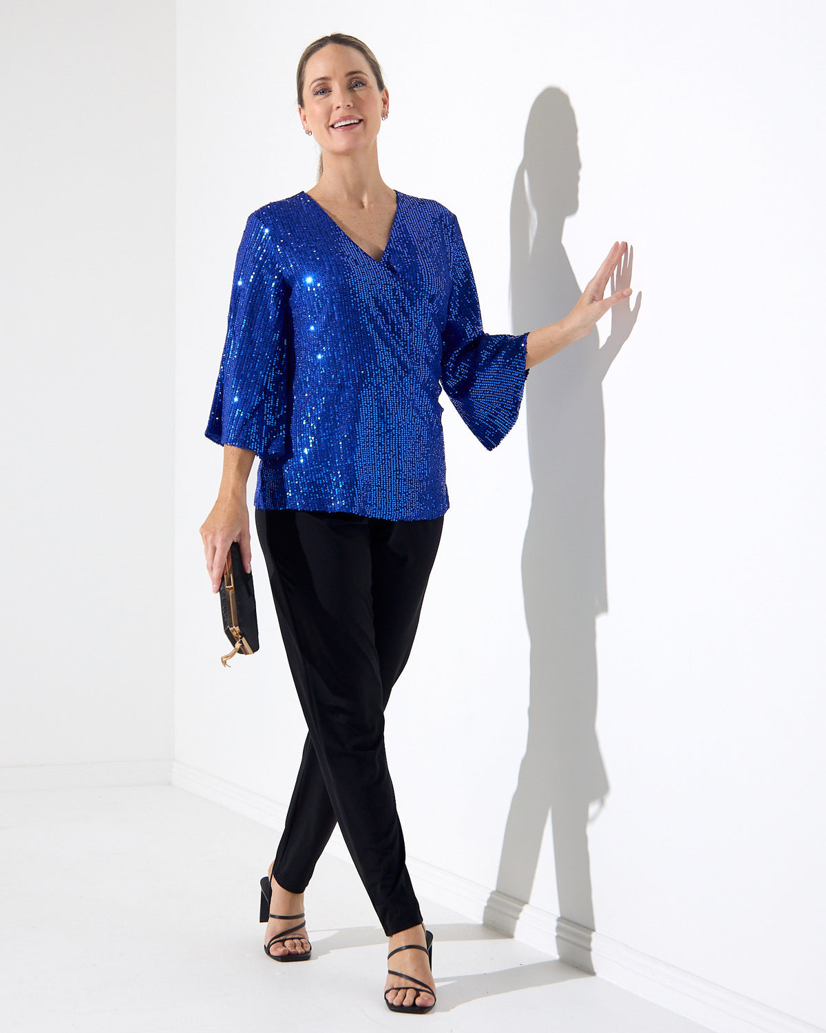 Sparkle Sequin Top in electric blue, full-length view walking, styled with black pants and heels
