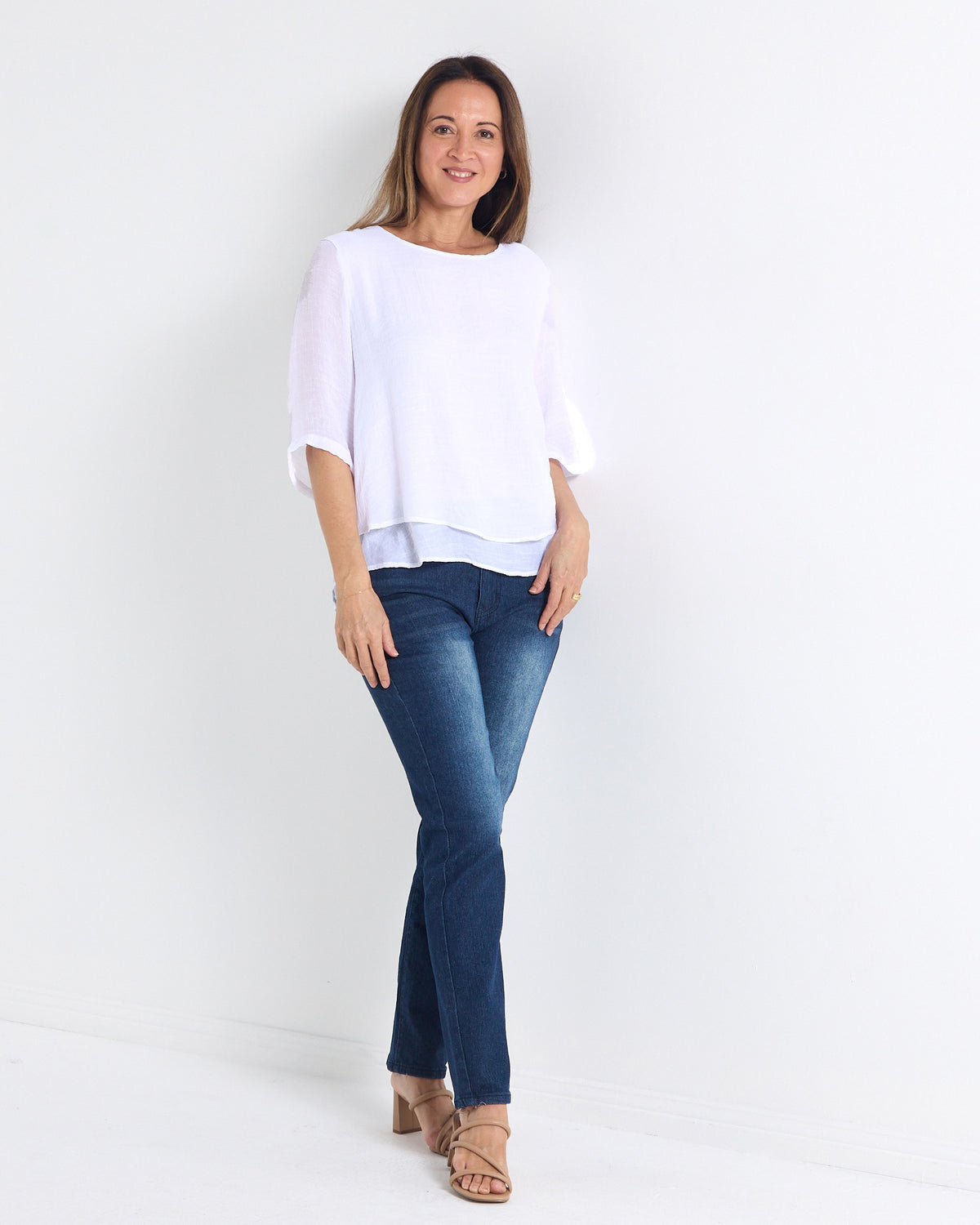 Leo Layered Top in white, full-length view styled with blue jeans and heels