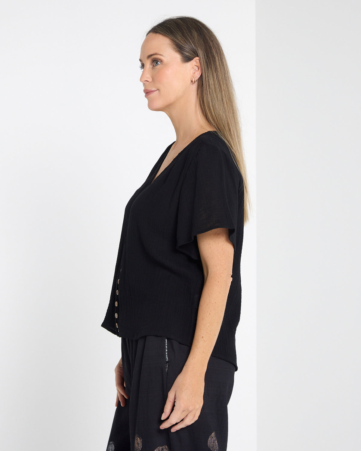 Tarin Button Top in black, side view showing the length and sleeve shape