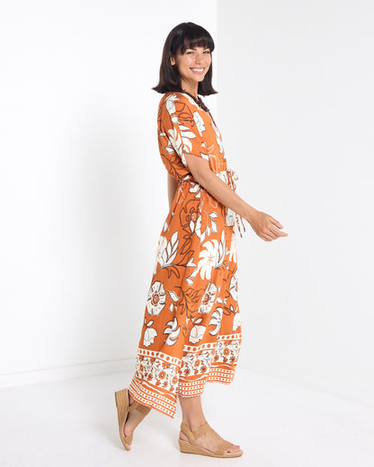 Montgomery Dress in toffee, side view walking, showing the midi length