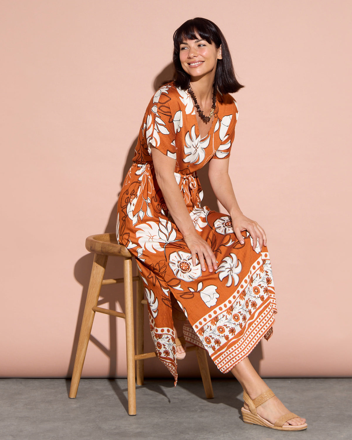 Montgomery Dress in toffee, seated view showing the side split and border print hem