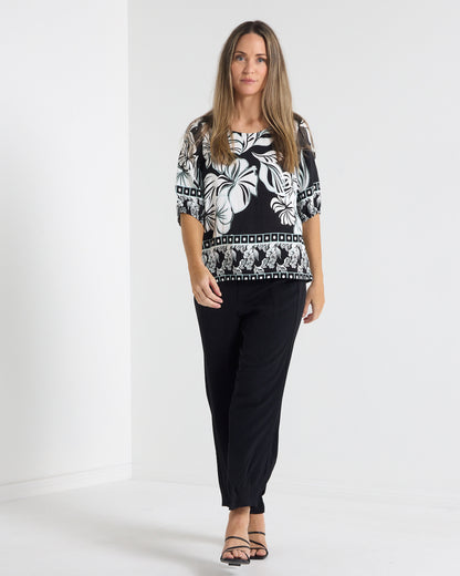 Falkiner Border Print Top in black, full-length view styled with black pants and heels