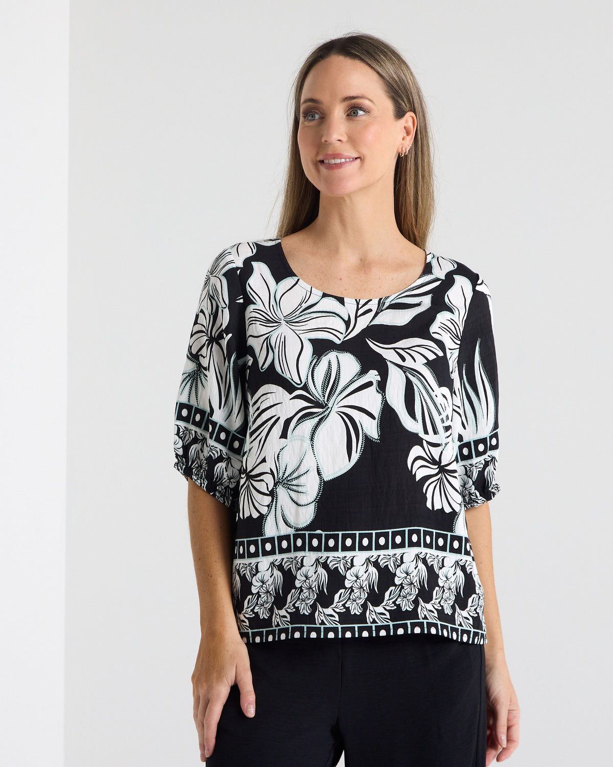 Falkiner Border Print Top in black, front view of the floral print and border hem