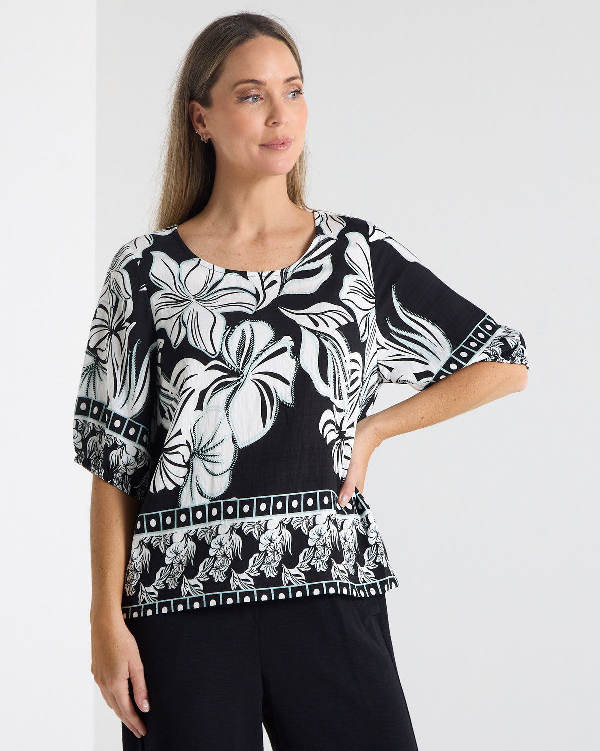 Falkiner Border Print Top in black, front view with hand on hip, showing the black and white floral print