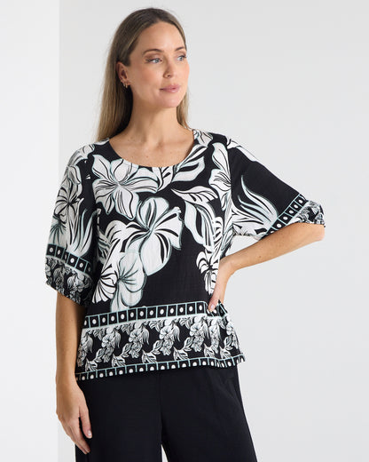 Falkiner Border Print Top in black, front view with hand on hip, showing the black and white floral print